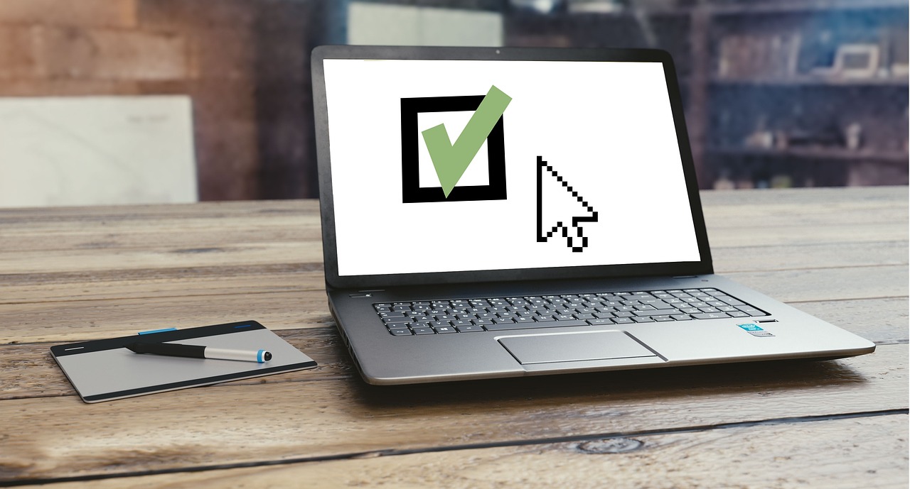 Laptop z zielonym znacznikiem wyboru symbolizującym zabezpieczenie i weryfikację